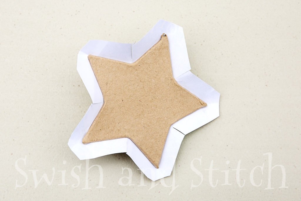 cutting the paper close to the papier mache star ornament