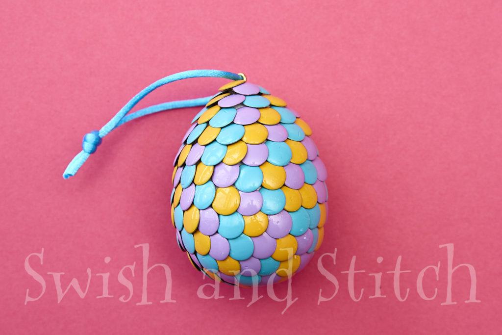 completed random thumbtack easter egg ornament on pink