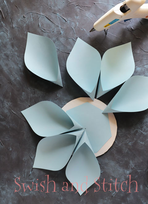 gluing the petals to the cardboard circle