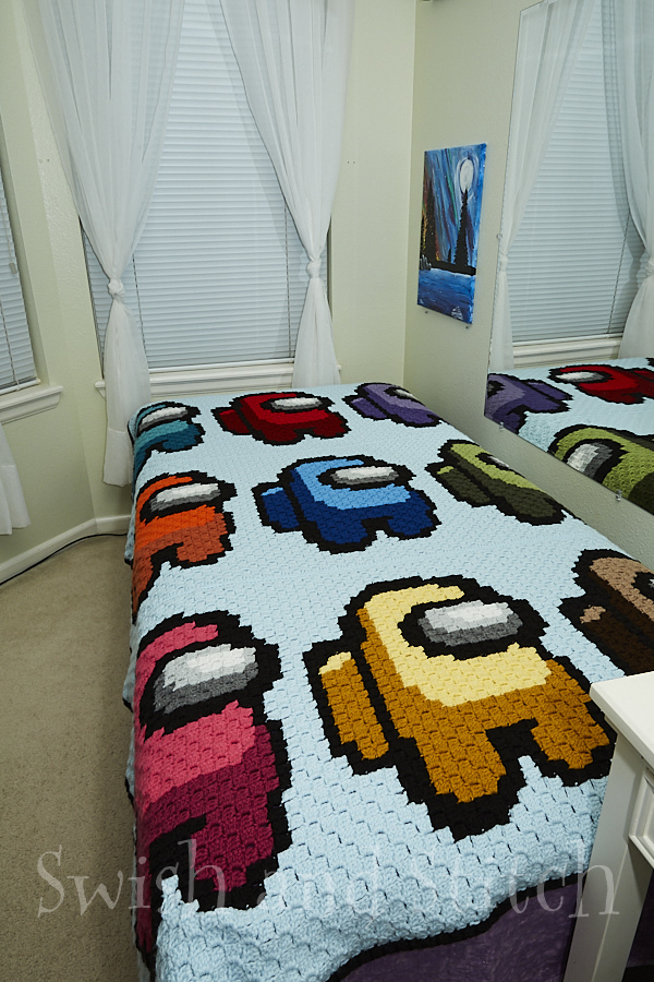 finished Among Us C2C crochet blanket on bed