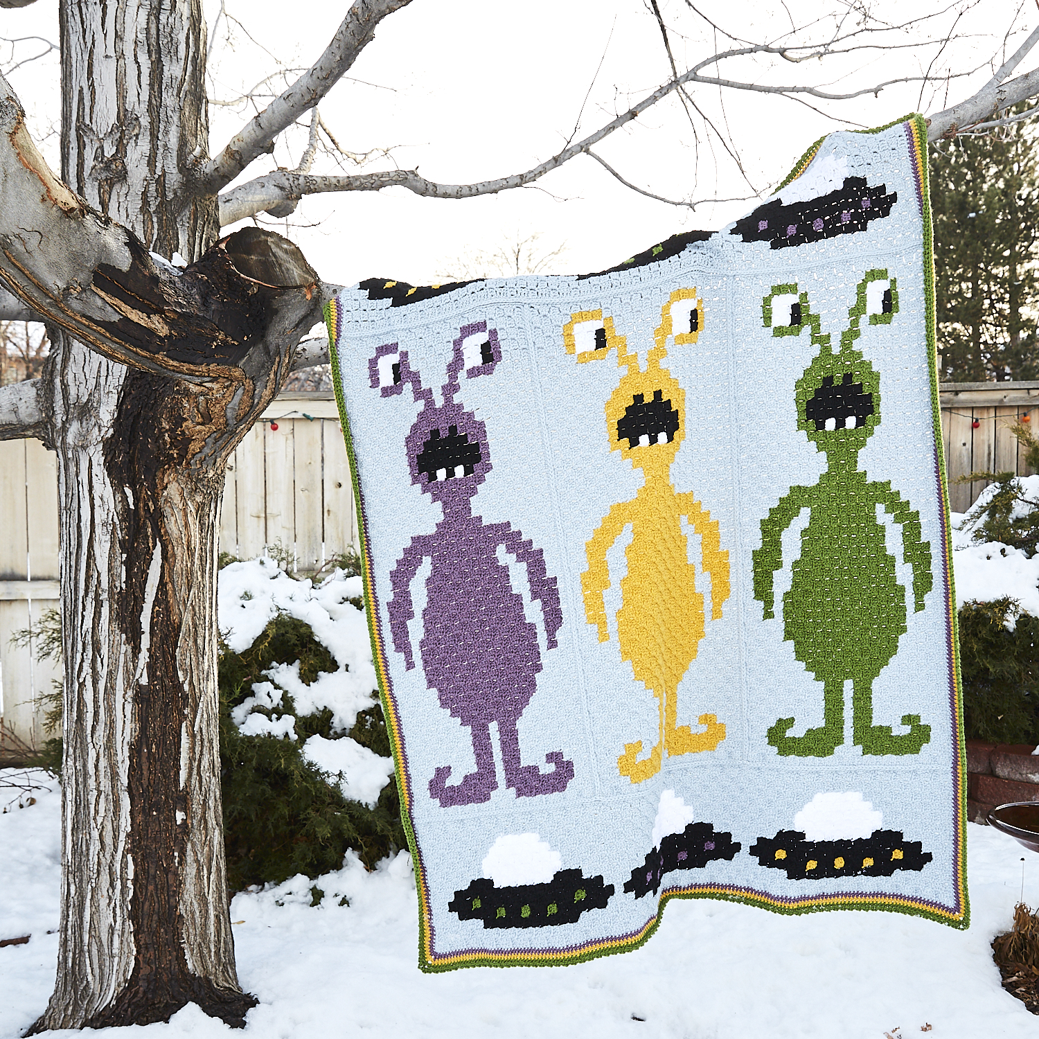 Take Me To Your Leader Afghan draped over tree