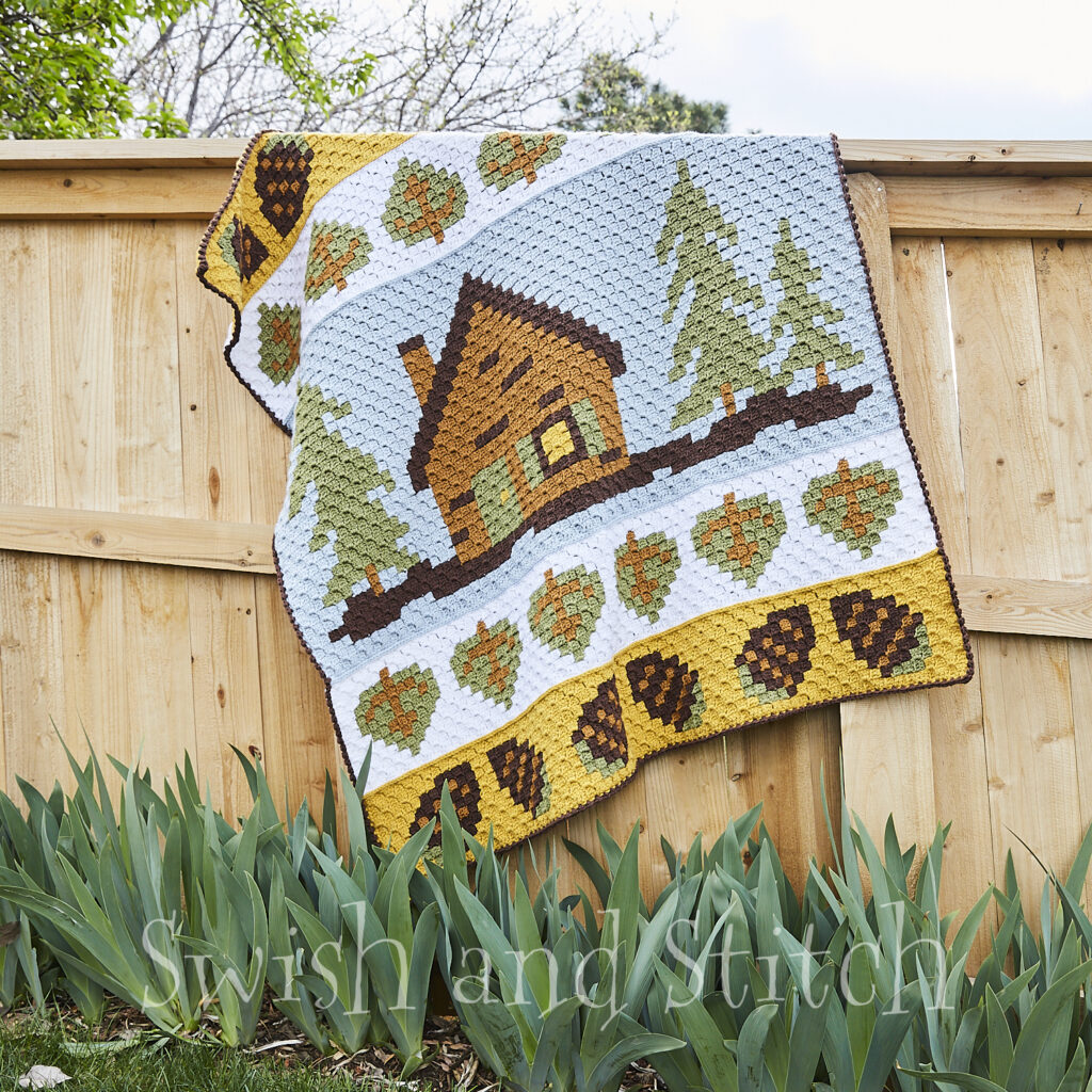 Summer Cabin C2C Crochet Afghan hanging on fence