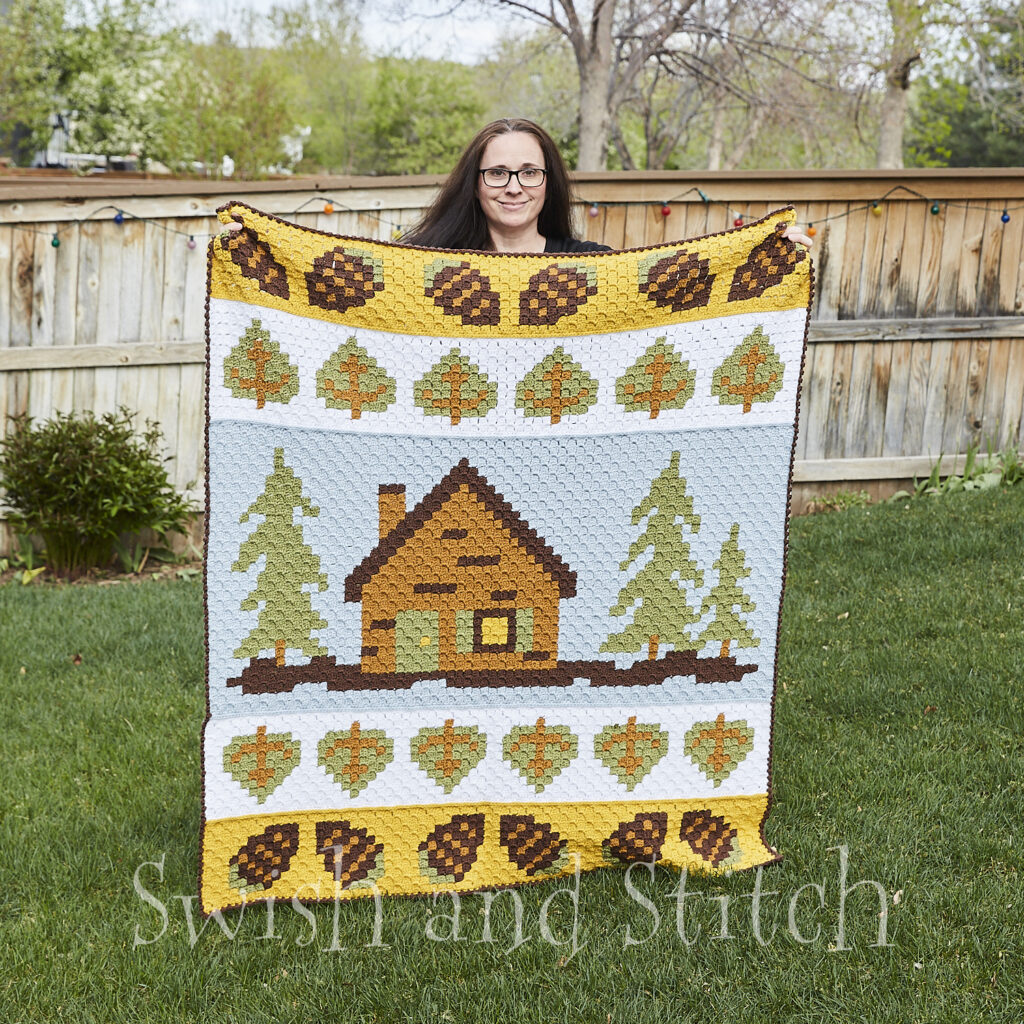 Summer Cabin C2C Crochet Afghan held by designer